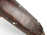 an old leather sheath with writing on it on a white surface