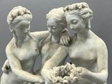a statue of three women and a man holding a baby