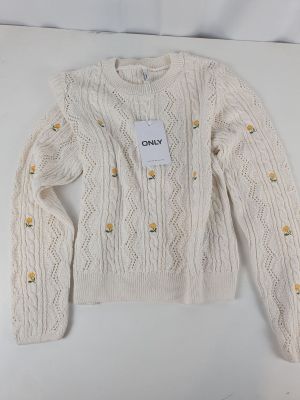 a white sweater with buttons and a tag on it