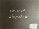 une image représentant un livre noir avec une inscription en blanc indiquant « signature masquée »