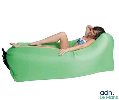 La femme est allongée sur un pouf vert.
