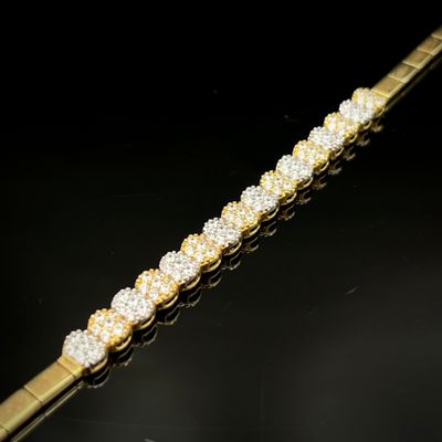 un gros plan d'un bracelet en or et diamants posé sur une surface noire