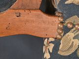 a close up of a wooden chair with a beaded bracelet on it