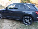 the rear end of a black audi suv parked in a field