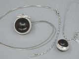 un collier en argent orné d'une perle noire et d'une chaîne en argent