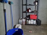 un seau bleu et une serpillière dans un coin de la pièce