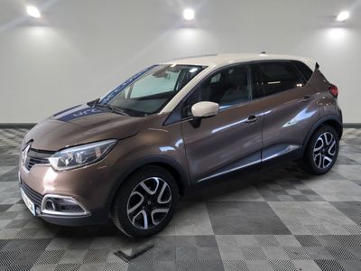 Une voiture marron et blanche est garée sur un sol à damier.