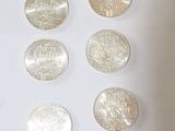 six different types of coins are shown on a white surface