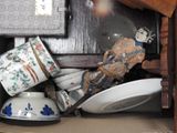 a pile of dishes and cups on a shelf