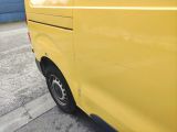 yellow van parked on the side of the road in a parking lot