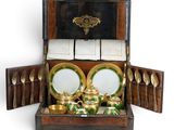 a wooden box with a tea set inside of it