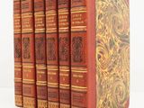 the books are lined up in a row on a white surface