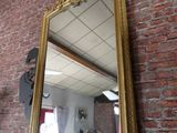 un miroir accroché au mur, à côté d'un mur en briques
