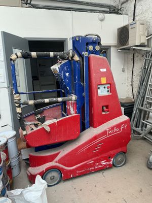 a red and blue scissor sitting in a garage
