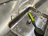 a metal pan with a spatula in it sitting on a counter