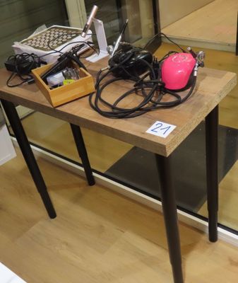 une petite table sur laquelle sont posés tout un tas d'appareils électroniques