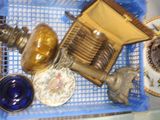 a blue basket filled with silver and glass items