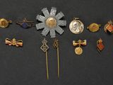 an image of a group of pins and brooches on a black surface