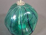 a green glass candle that is sitting on a table