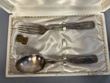 a silver spoon and fork in a white box