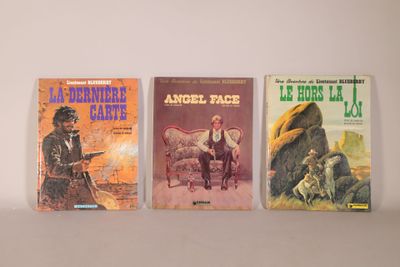 three books are lined up on a shelf on a white surface