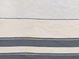 the white and blue striped towel is laying on the bed