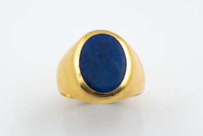 un gros plan d'une bague en or sertie d'un lapis-lazuli