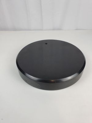 un gros plan d'un objet circulaire noir sur une surface blanche