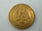 a close up of a gold coin on a white surface