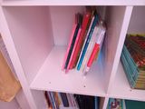 a book shelf with books on it in a small room