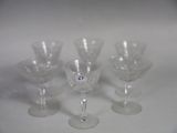 four wine glasses sitting on a table with a white background