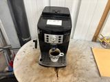 a coffee maker sitting on a table with a cup of coffee
