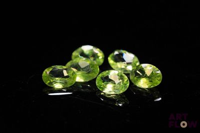 a group of green gems sitting on top of a black surface