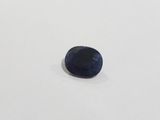 a blue sapphire stone on a white surface