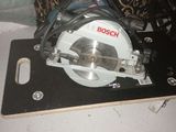 the circular saw is sitting on top of a table next to a pillow
