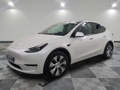 La Tesla Model Y blanche est garée dans une grande pièce.