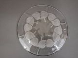 a glass bowl with white leaves in it on a table