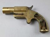 a close up of a brass revolver on a white surface