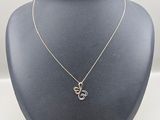 a silver necklace with a heart shaped pendant on a mannequin