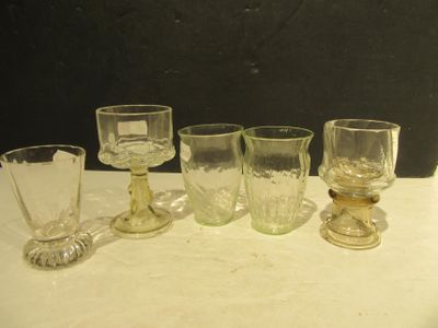 five glasses and a spoon sitting on a table