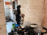 un plan de travail noir sur lequel sont posés des casseroles et des poêles, dans la cuisine