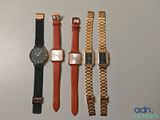 four different watches are lined up on a white surface