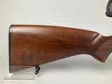 a close up of a wooden rifle with a scope on it
