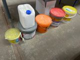 de nombreux seaux de peinture posés par terre