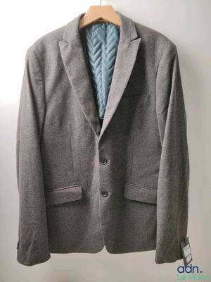 la veste est suspendue à un cintre sur le mur