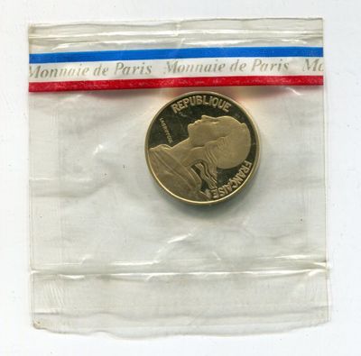 a coin in a plastic bag with a ribbon around it