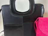 black and pink purse with mirror on top of it next to a pink purse