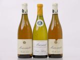 trois bouteilles de vin sont alignées sur une surface blanche