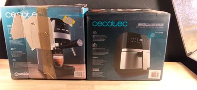 two boxes of coffee machines sitting on a table next to each other