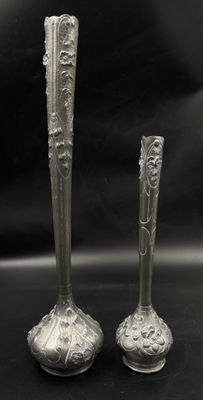two silver vases sitting next to each other on a table